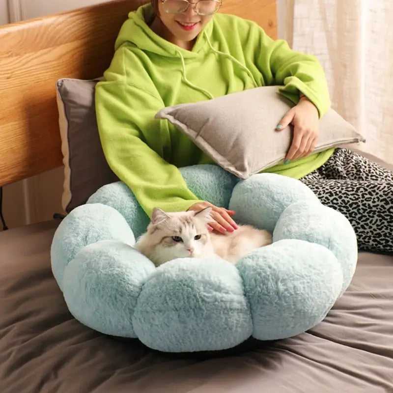 Femme assise sur le lit avec son chat à côté du Super Soft Washable Flower Cushion for Cats, Fleurs Lavable super