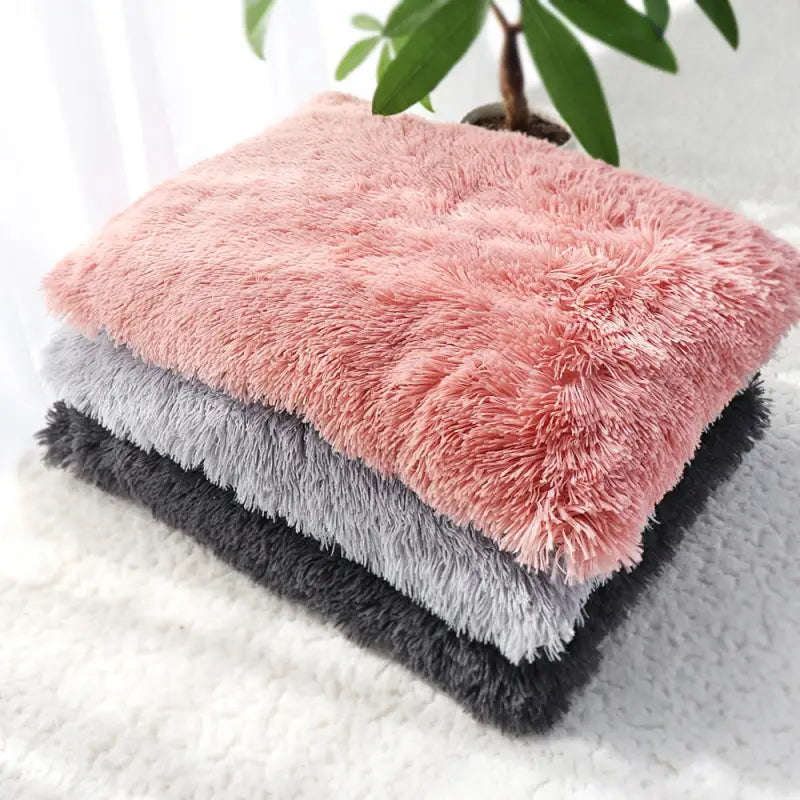 Lit douillet pour chien avec un coussin en peluche rose et gris sur un tapis blanc
